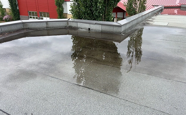 ponding on a flat commercial roof, commercial flat roof drainage, flat roof repair Asheville, commercial roofing Asheville NC, stop roof ponding, commercial roof drainage solutions, flat roof water pooling, flat roof commercial repair, commercial roof leaks, flat roof replacement Asheville, TPO commercial roofing, EPDM roof ponding fix, prevent commercial roof damage, roof maintenance Asheville business, commercial roof inspection service